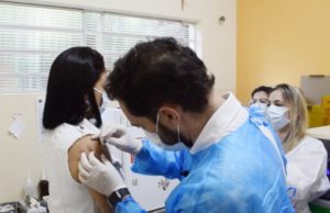 Taquarituba e cidades da região também iniciam vacinação contra a covid-19 Prefeito Éder Miano (PP) aplica a dose na técnica de enfermagem Simone de Oliveira. (Foto: Divulgação)