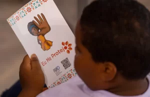 Guarda civil é preso no RN após investigação sobre abuso sexual de criança de Timburi Criança segura a cartilha da campanha 'Eu Me Protejo'. Imagem ilustrativa. (Foto: Fabio Rodrigues-Pozzebom/Agência Brasil)